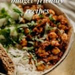 a bowl of vegan food containing rice, chickpeas in a sauce, chopped cucumbers, and cilantro, with a piece of bread on the side, and an overlay text reading "10 iron-rich VEGAN MEALS budget-friendly recipes"