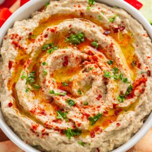 Eggplant baba ganoush spread in a bowl with pita and dippers.