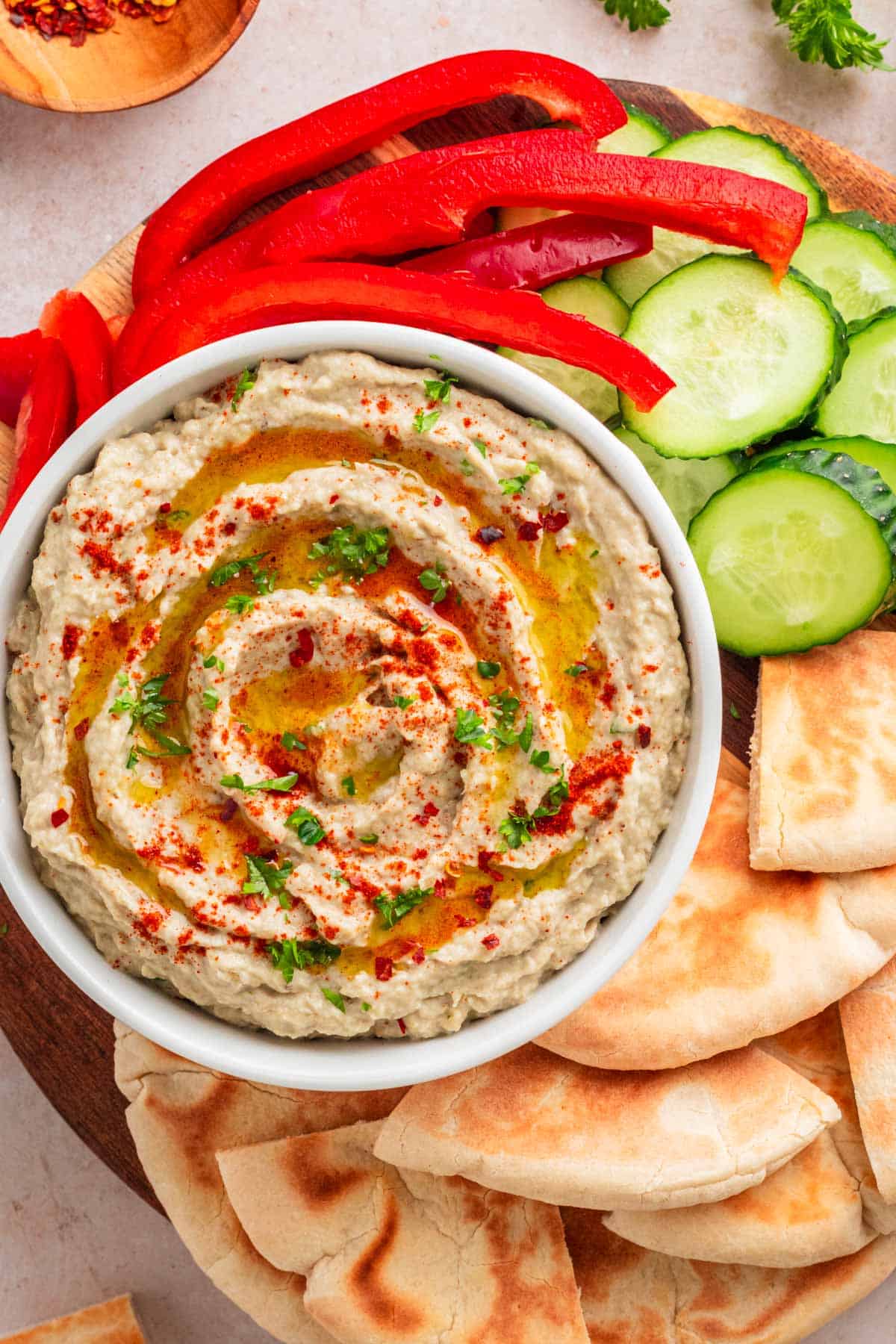 Eggplant baba ganoush spread in a bowl with pita and dippers.