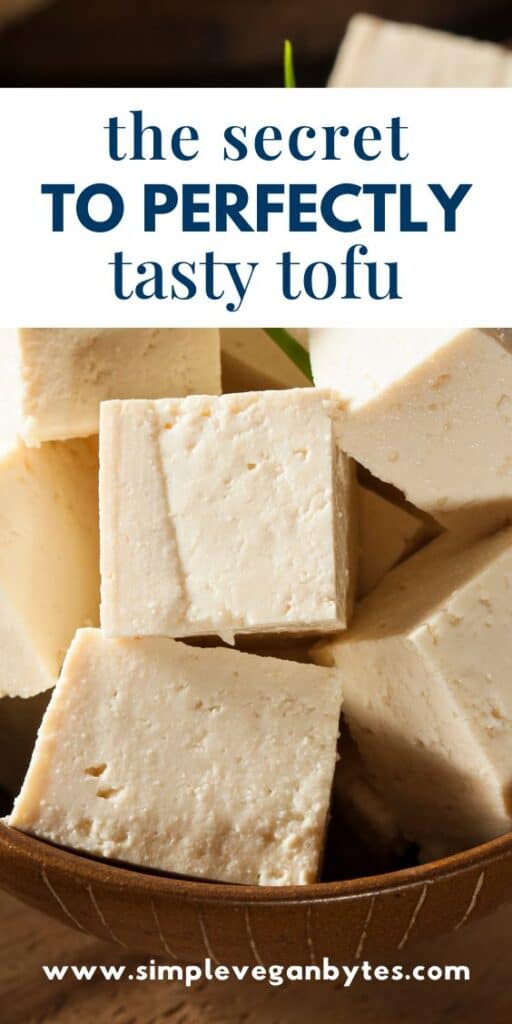 cubed tofu on a wooden plate with text 'the secret to perfectly tasty tofu'