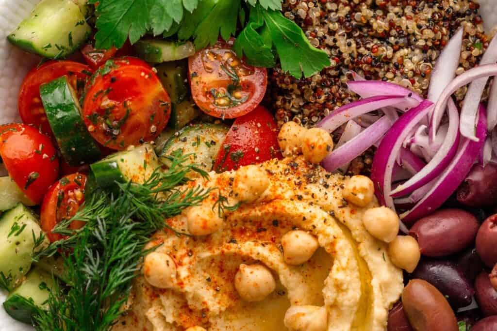 Mediterranean hummus bowl with chickpeas, tomatoes, cucumbers, and olives