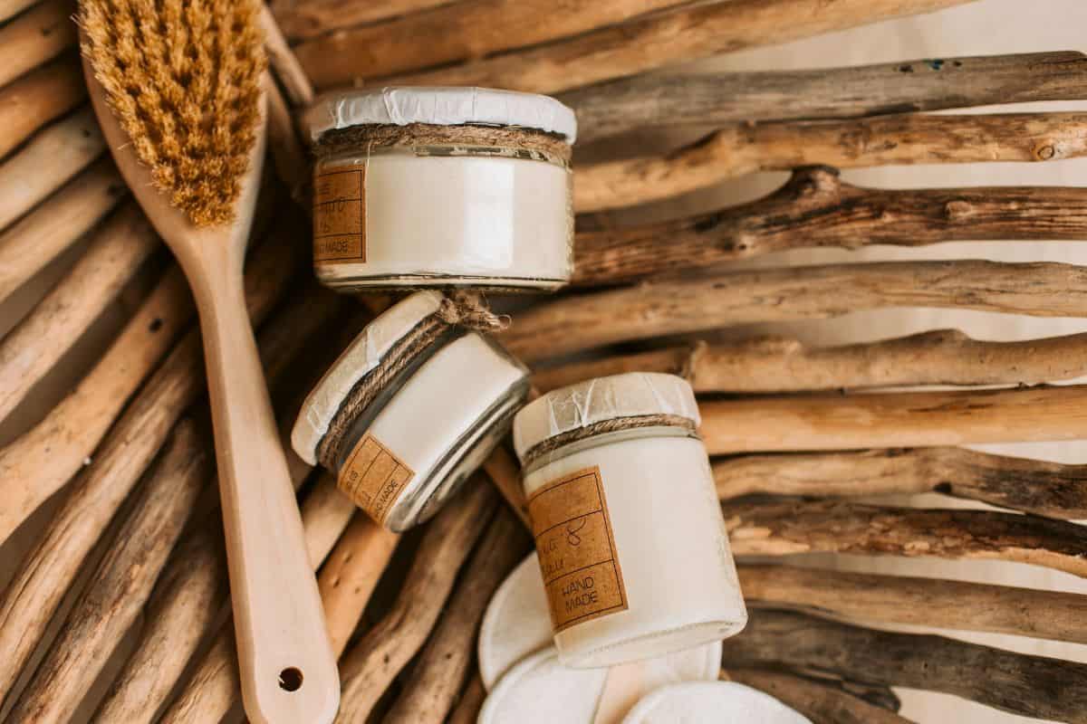 Natural skincare jars with wooden brush on rustic surface