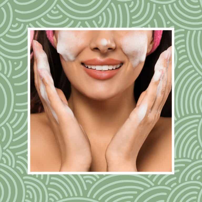 Woman cleansing face with gentle foam and smiling close-up.