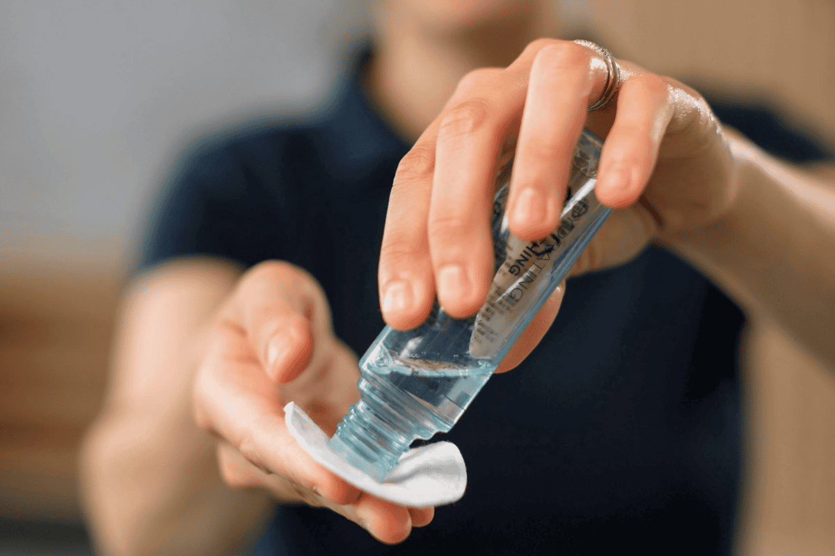 Applying toner to cotton pad for hydration step in skincare