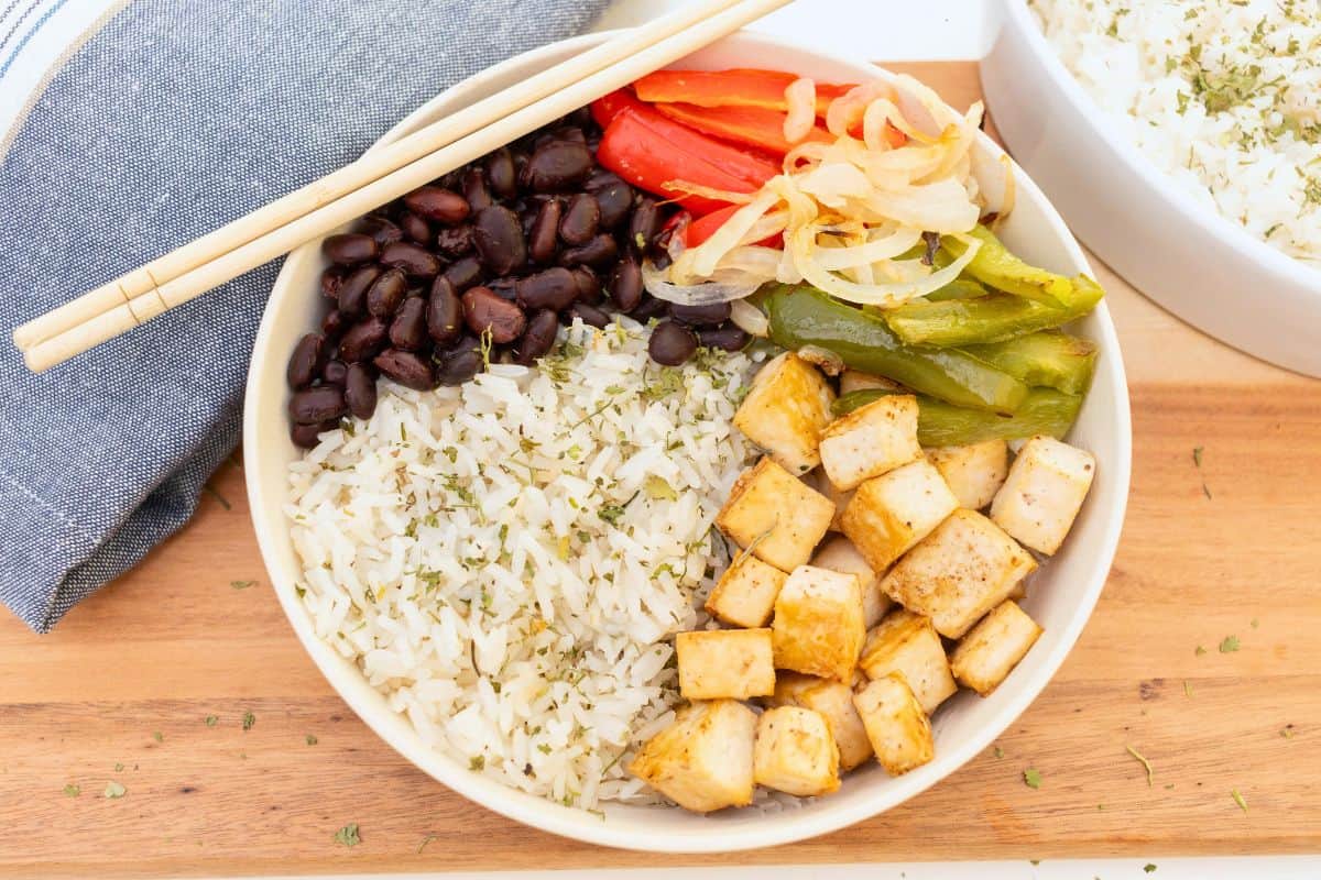 Vegan rice bowl with tofu, black beans, and vegetables