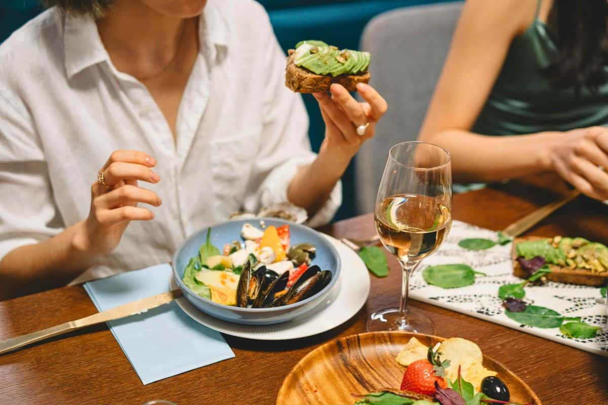 Friends eating healthy meals at a restaurant table