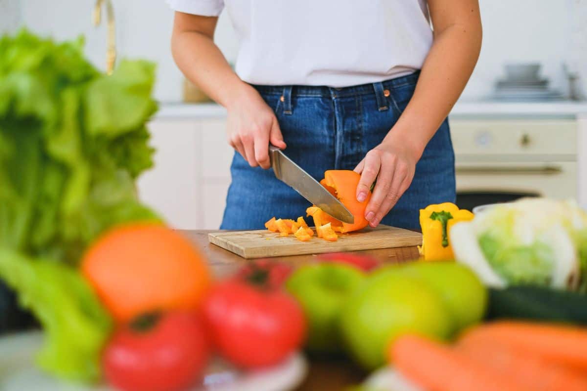Person chopping vegetables in a bright kitchen