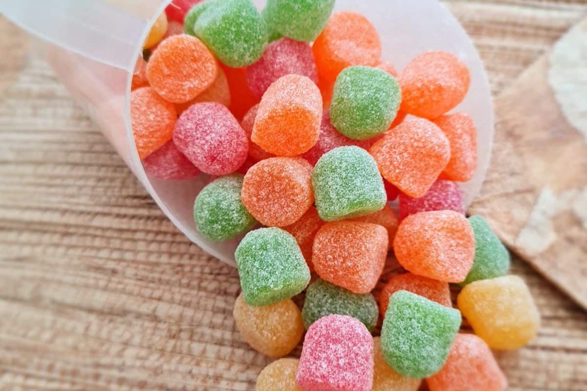 Colorful gummy candies spilling from a plastic container