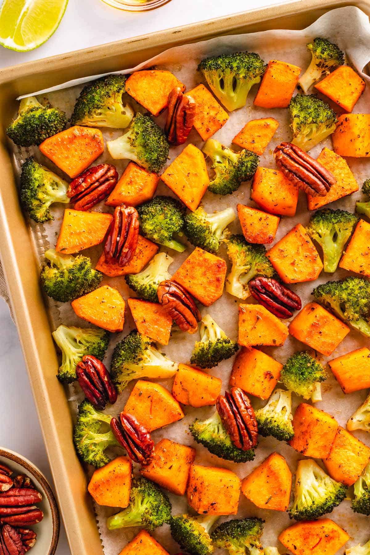 Sheet pan roasted sweet potatoes, broccoli, and pecans before serving