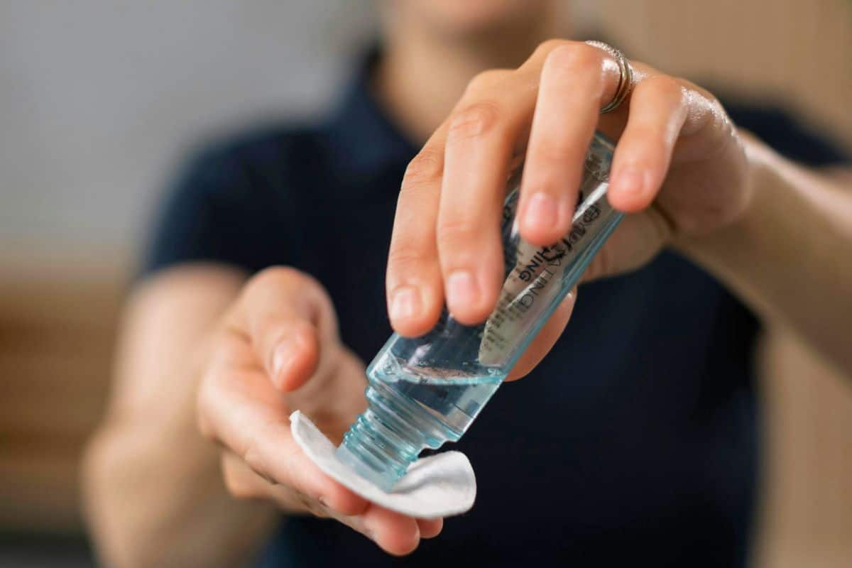 Person applying skincare toner onto a cotton pad