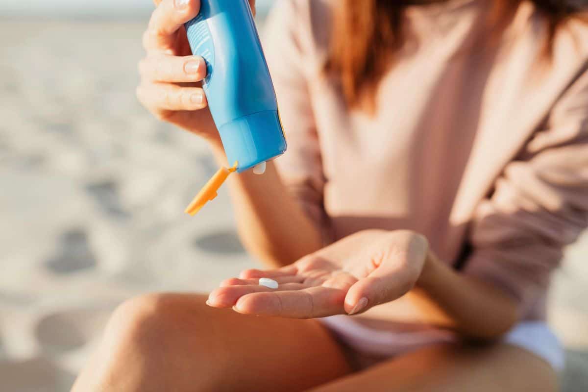 Woman applying sunscreen outdoors at the beach