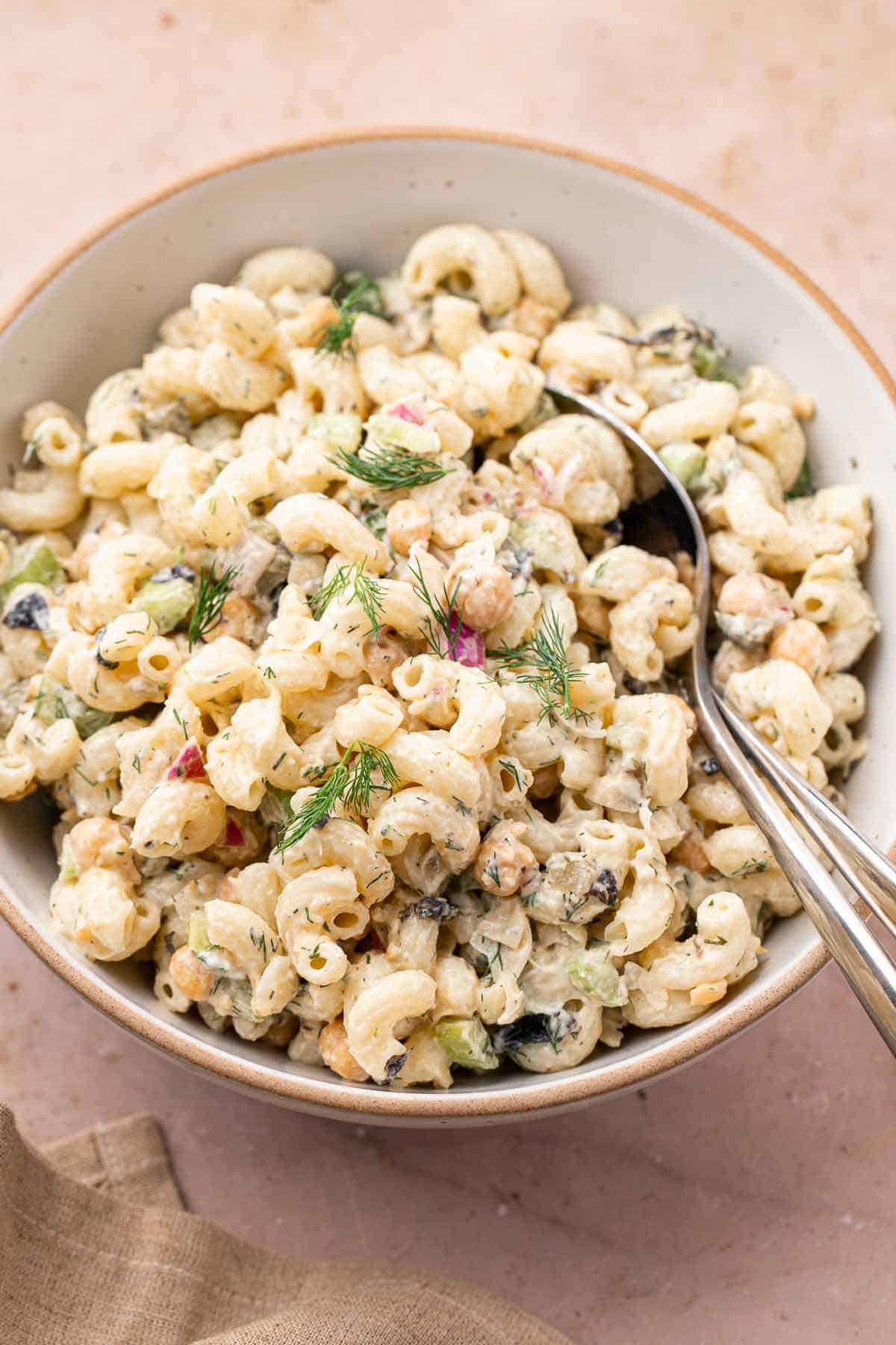 Chickpea pasta salad with creamy dressing and serving spoon