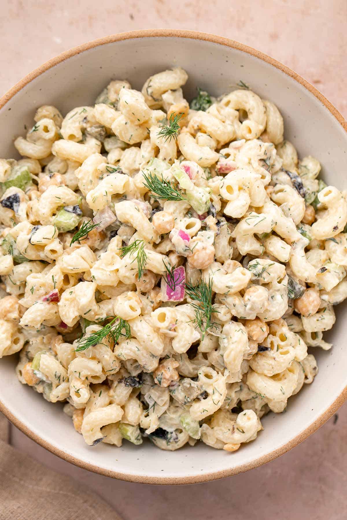 Close-up of creamy chickpea pasta salad with fresh dill garnish