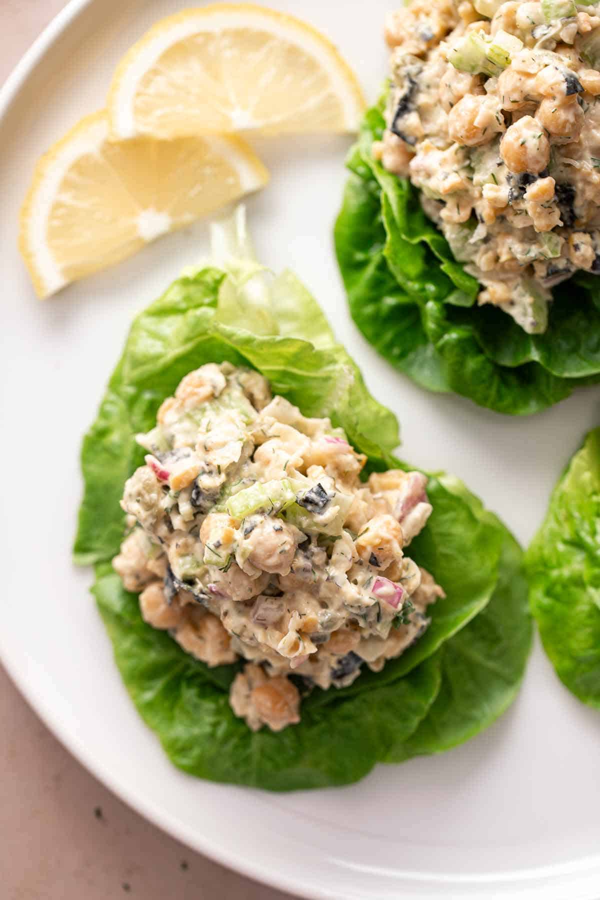 Creamy vegan chickpea salad in a bowl with lemon garnish