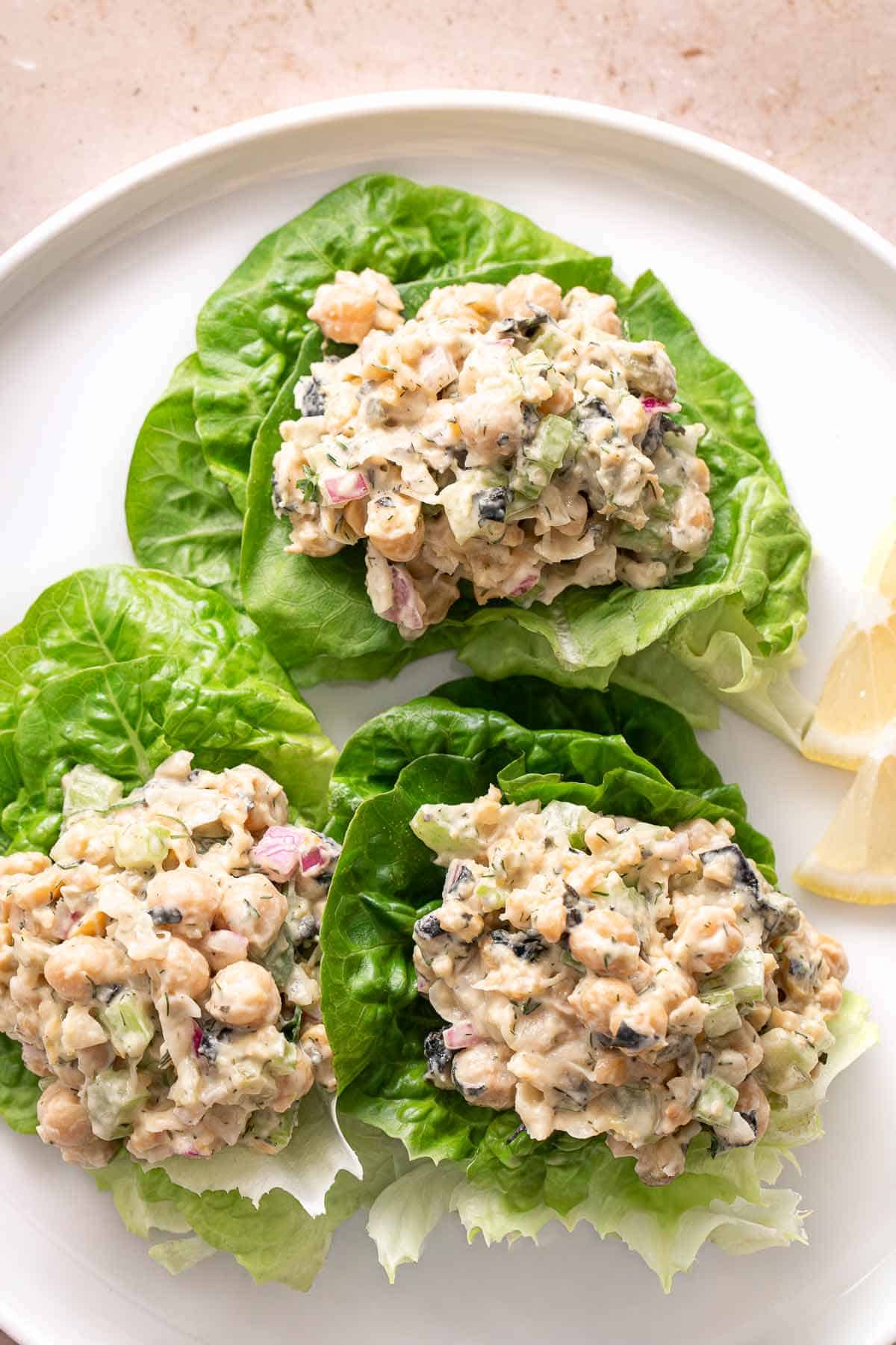 Chickpea salad served in fresh lettuce wraps with lemon wedges
