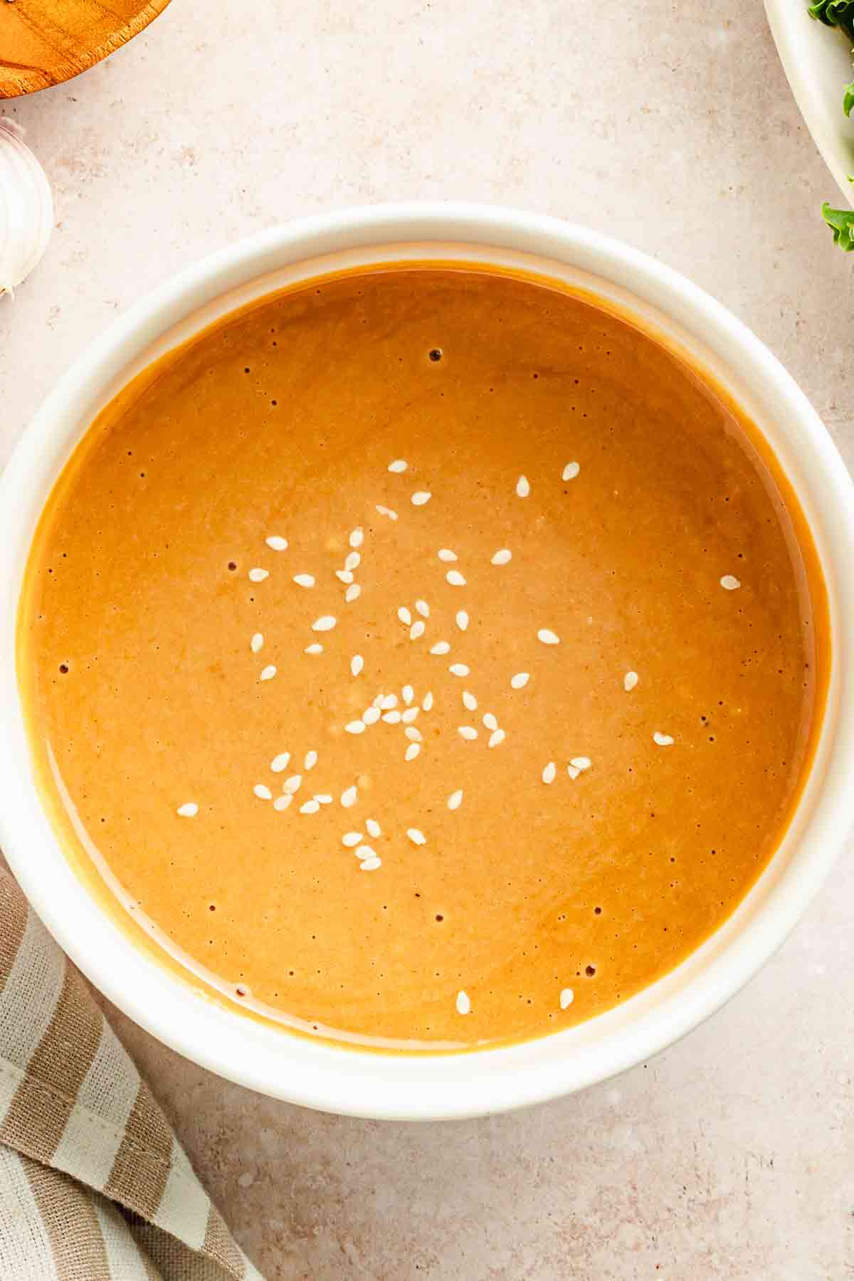 Creamy miso tahini dressing topped with sesame seeds in a white bowl