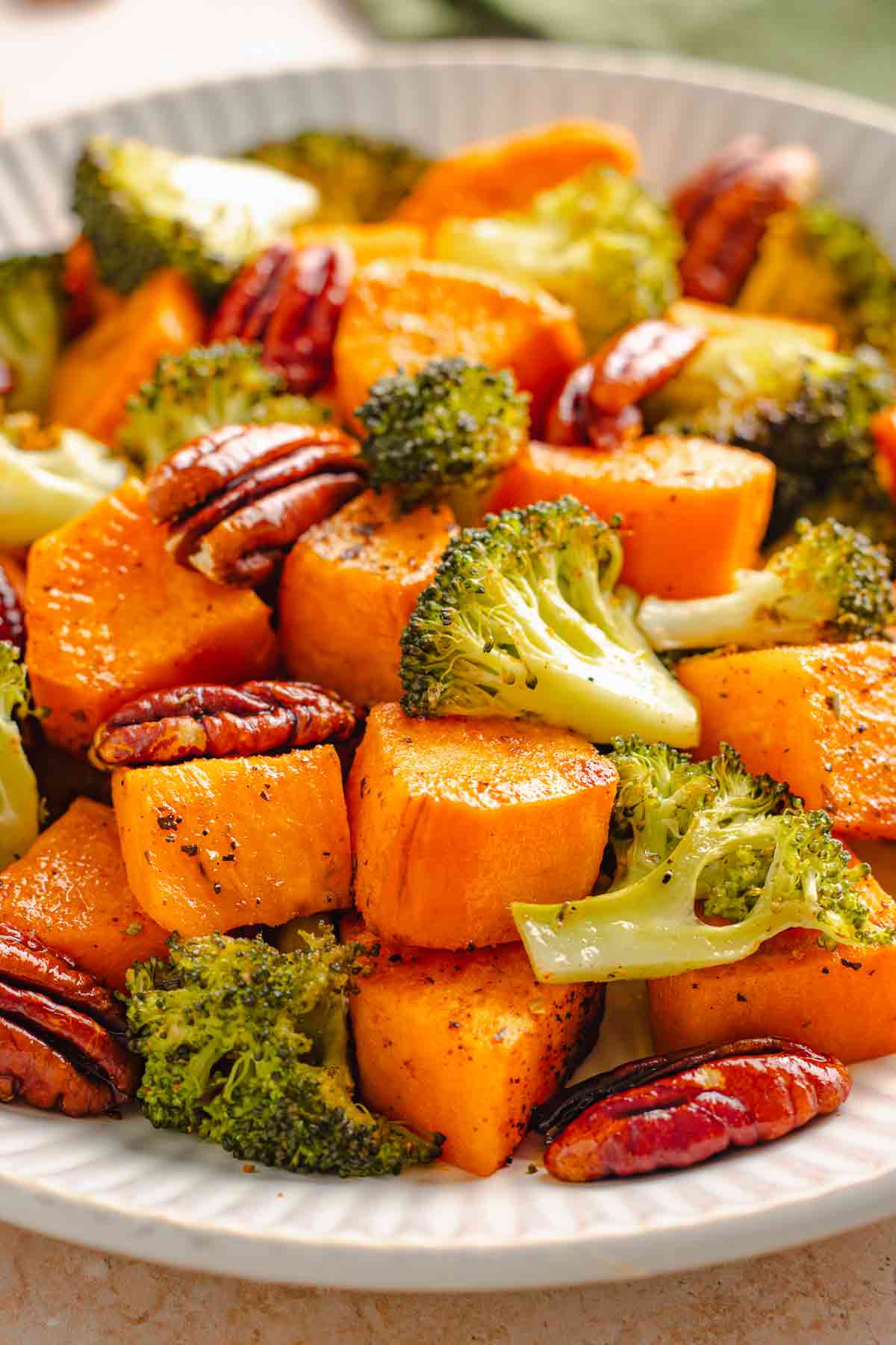 Roasted sweet potatoes and broccoli with pecans in a serving bowl