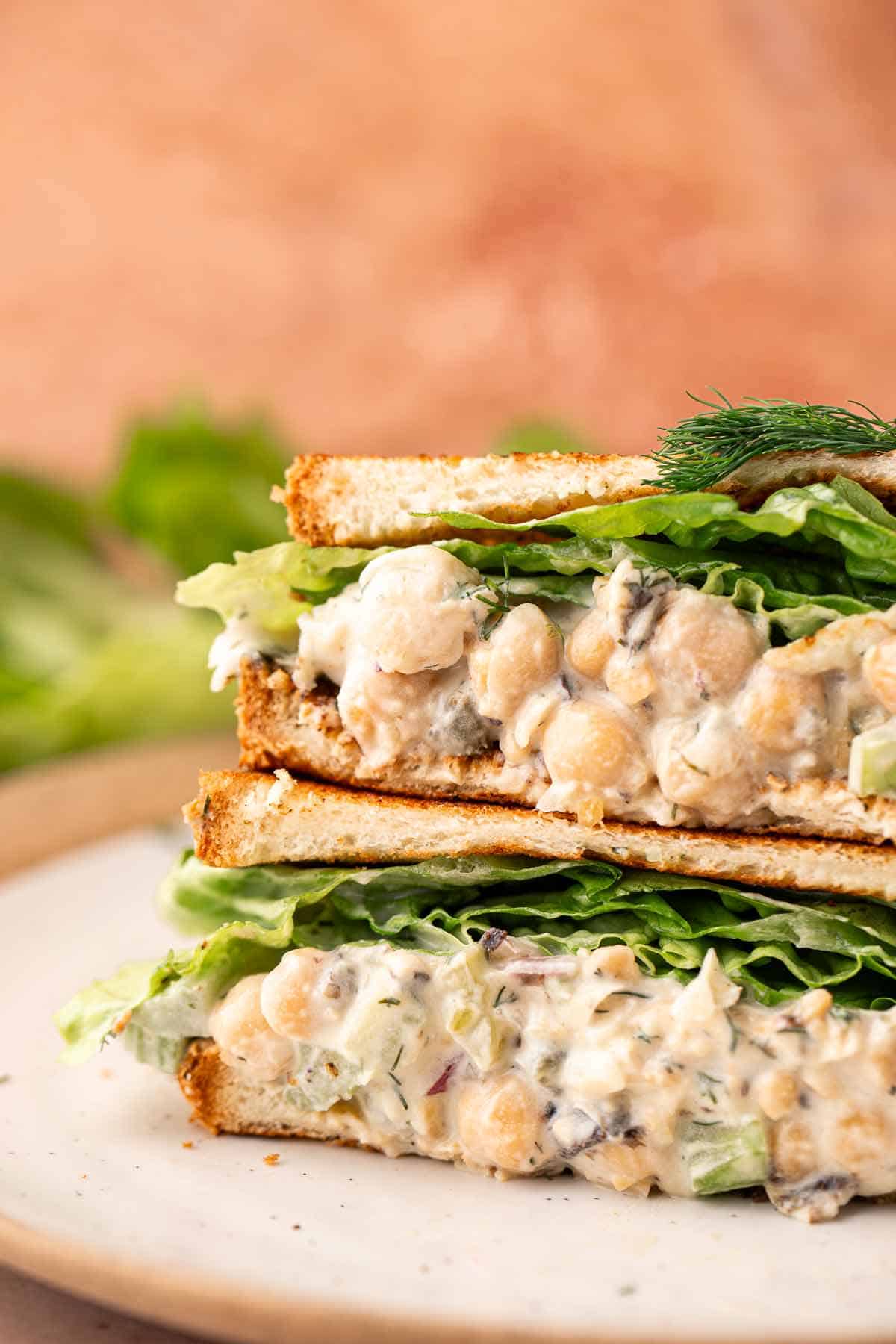 Close-up of creamy chickpea salad sandwiches with lettuce and fresh dill