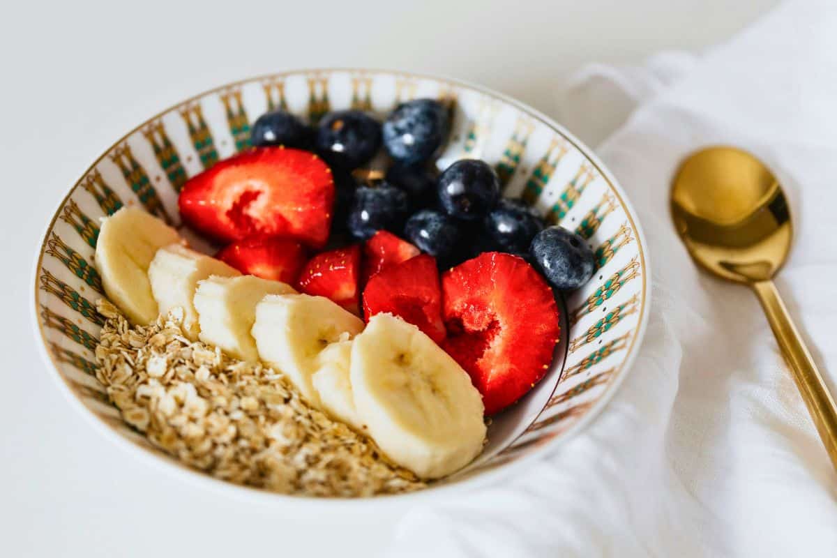 Bowl of oatmeal topped with banana, strawberries, and blueberries