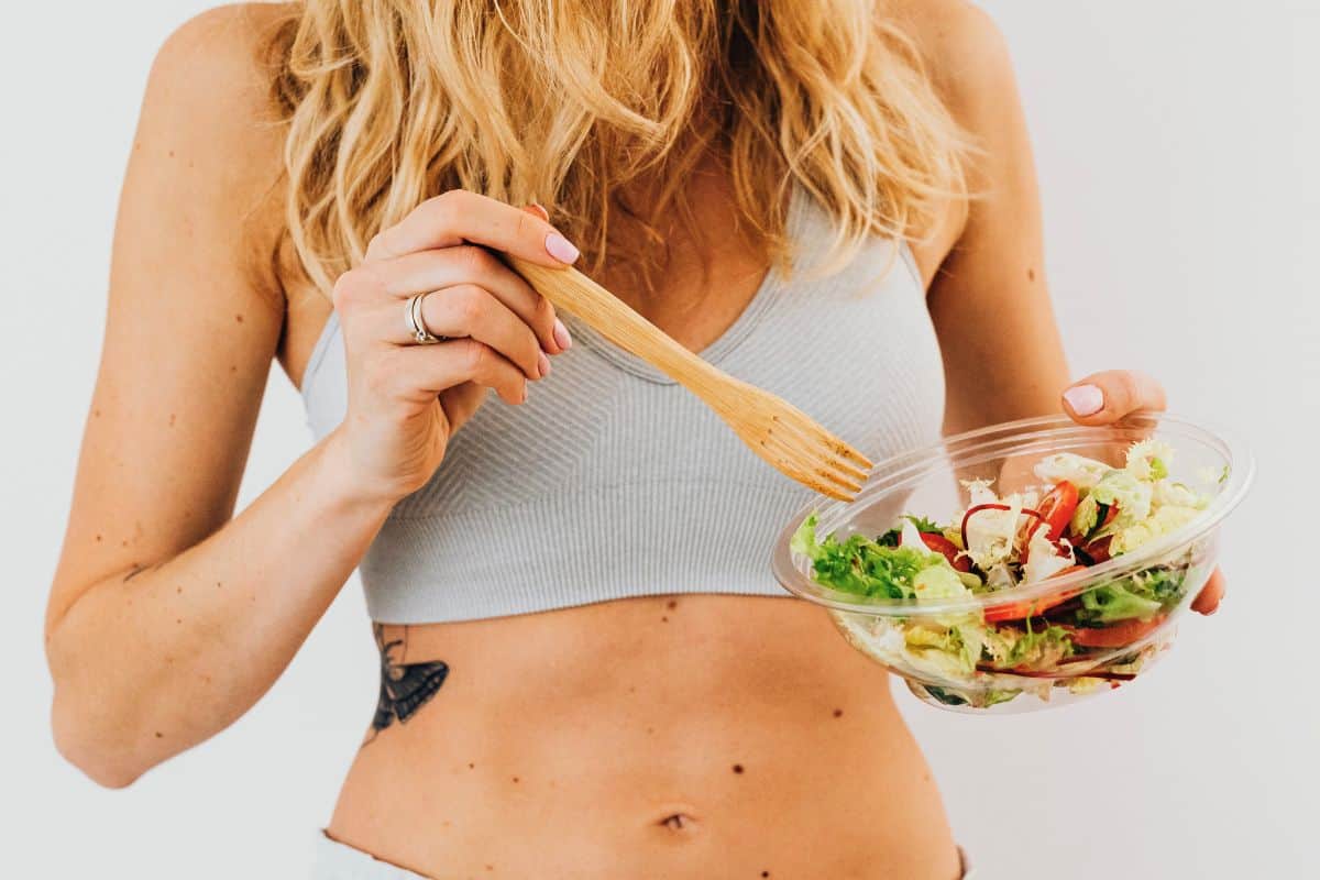 Woman eating salad from a bowl with a fork