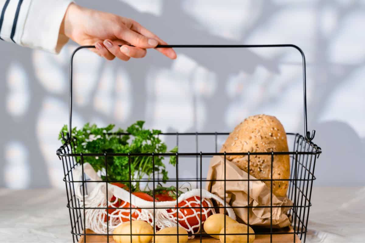 Grocery basket with bread, vegetables, and fresh produce