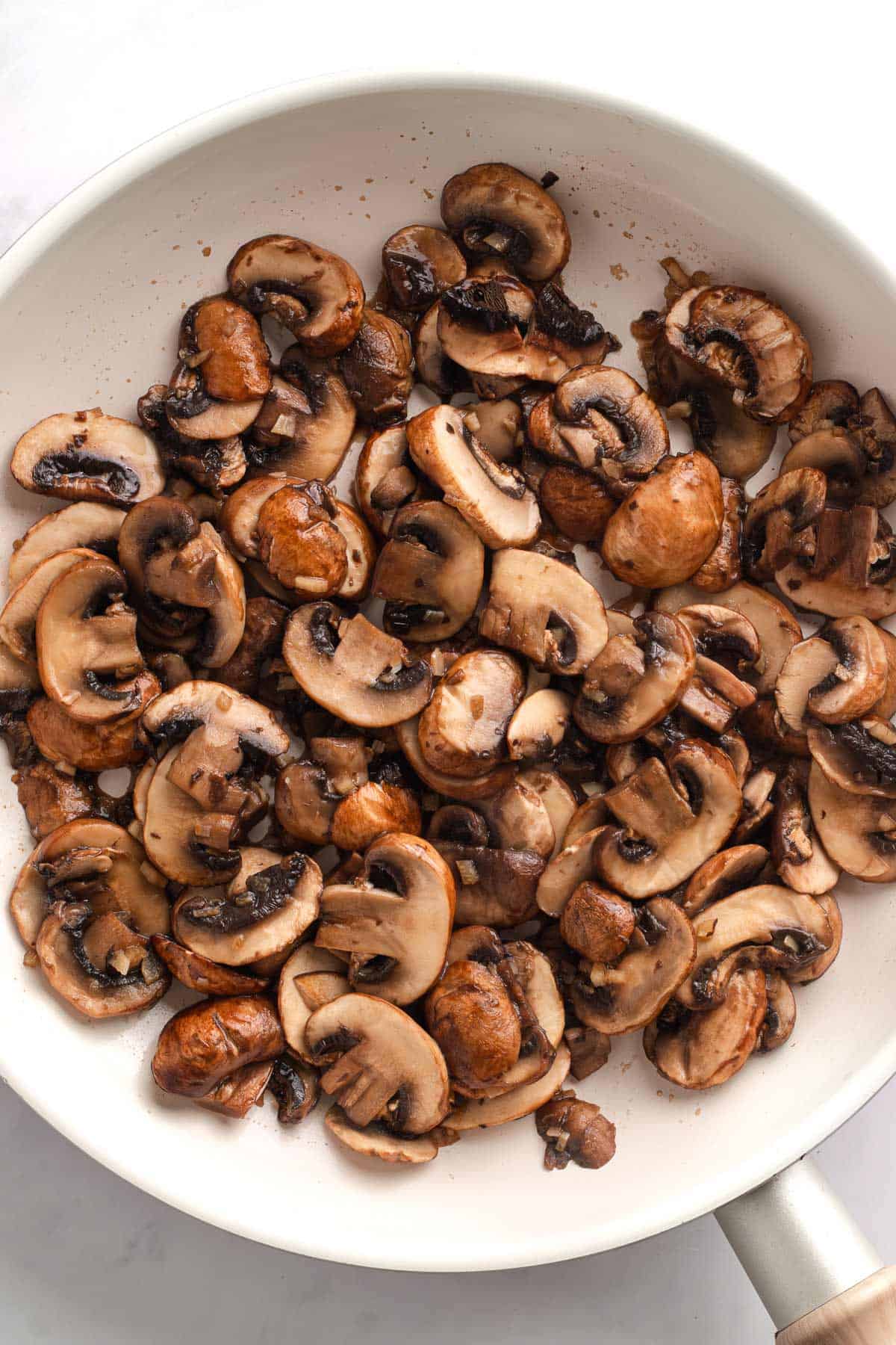 Mushrooms browned in a skillet before adding the spicy sauce.