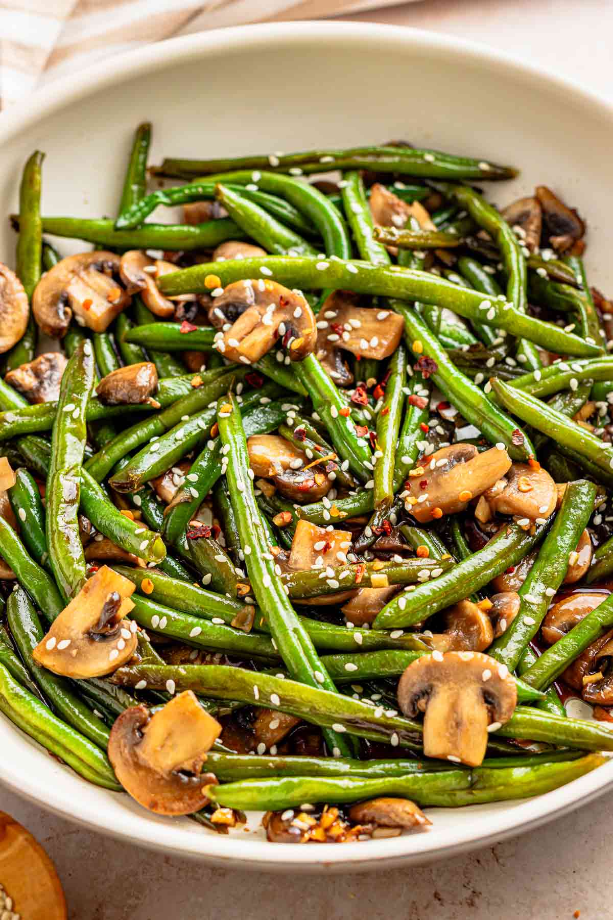 Garlic soy green beans and mushrooms coated in glossy sauce with sesame seeds