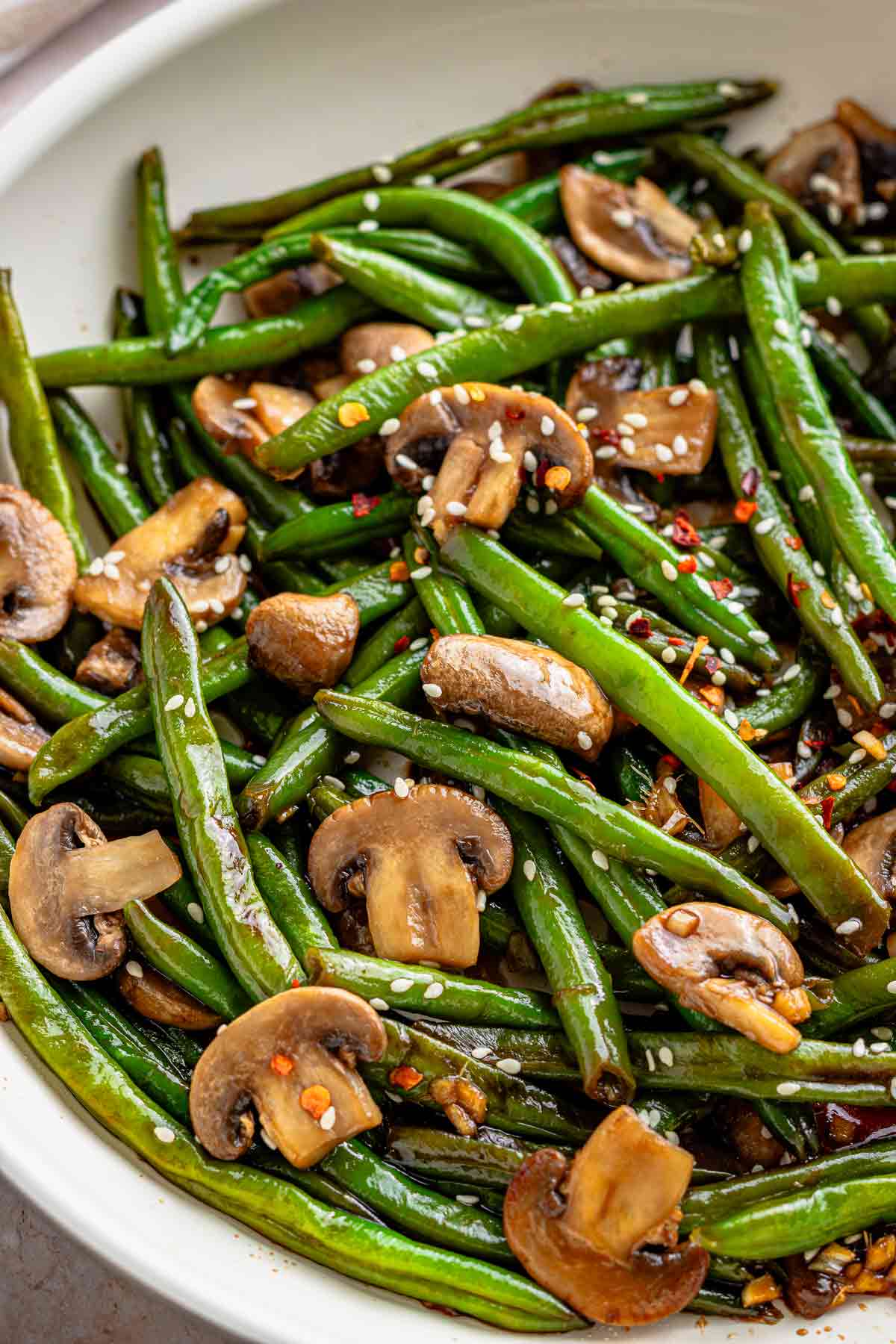 Close-up of vegan garlic soy green beans with mushrooms and sesame seeds