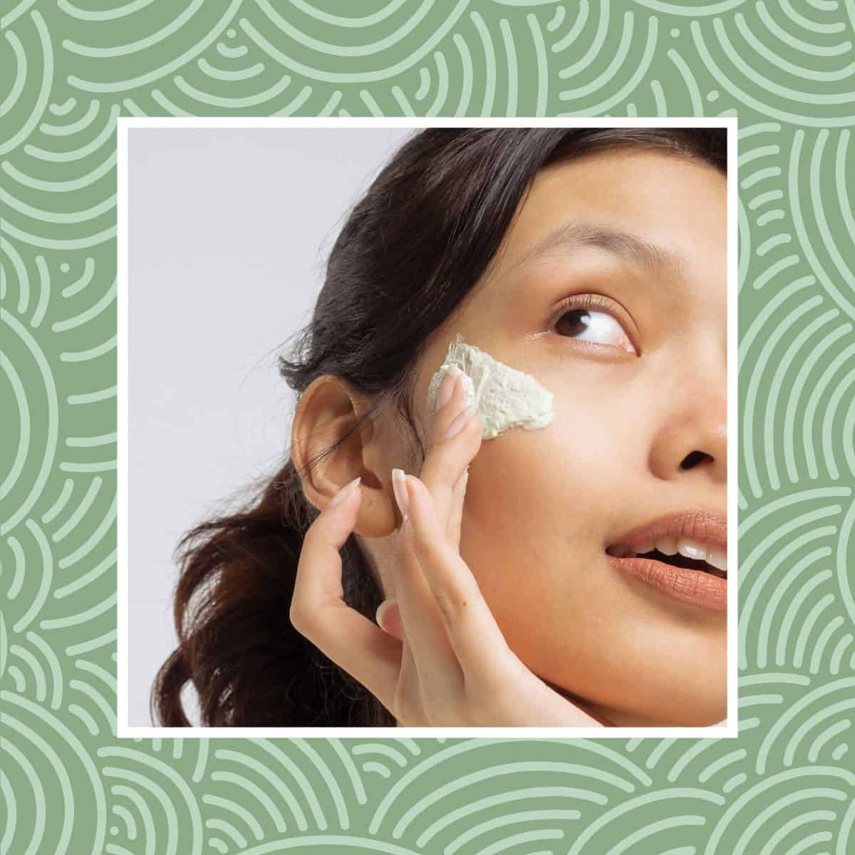 Woman applying a skincare cream to her cheek, framed by a green patterned border.