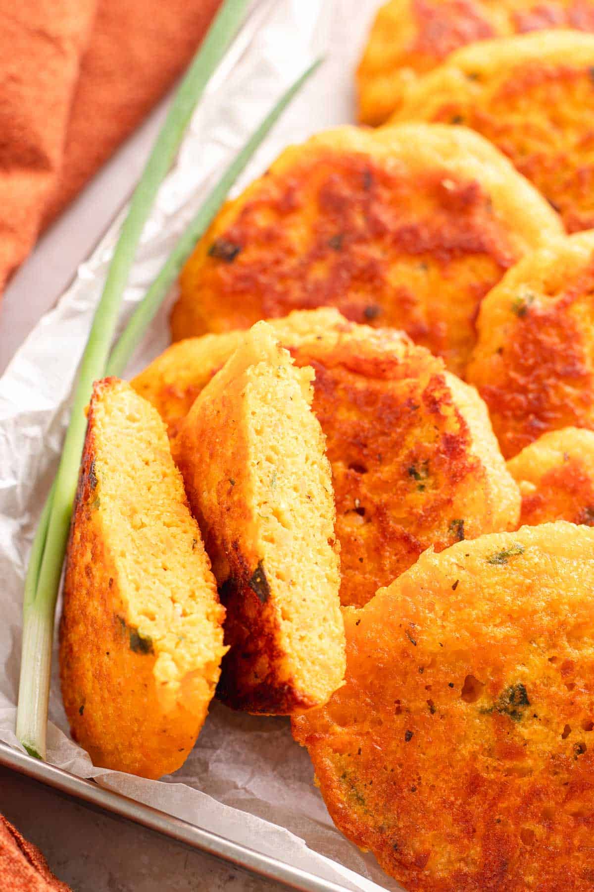 Cooked sweet potato lentil fritters with one cut open to show the center
