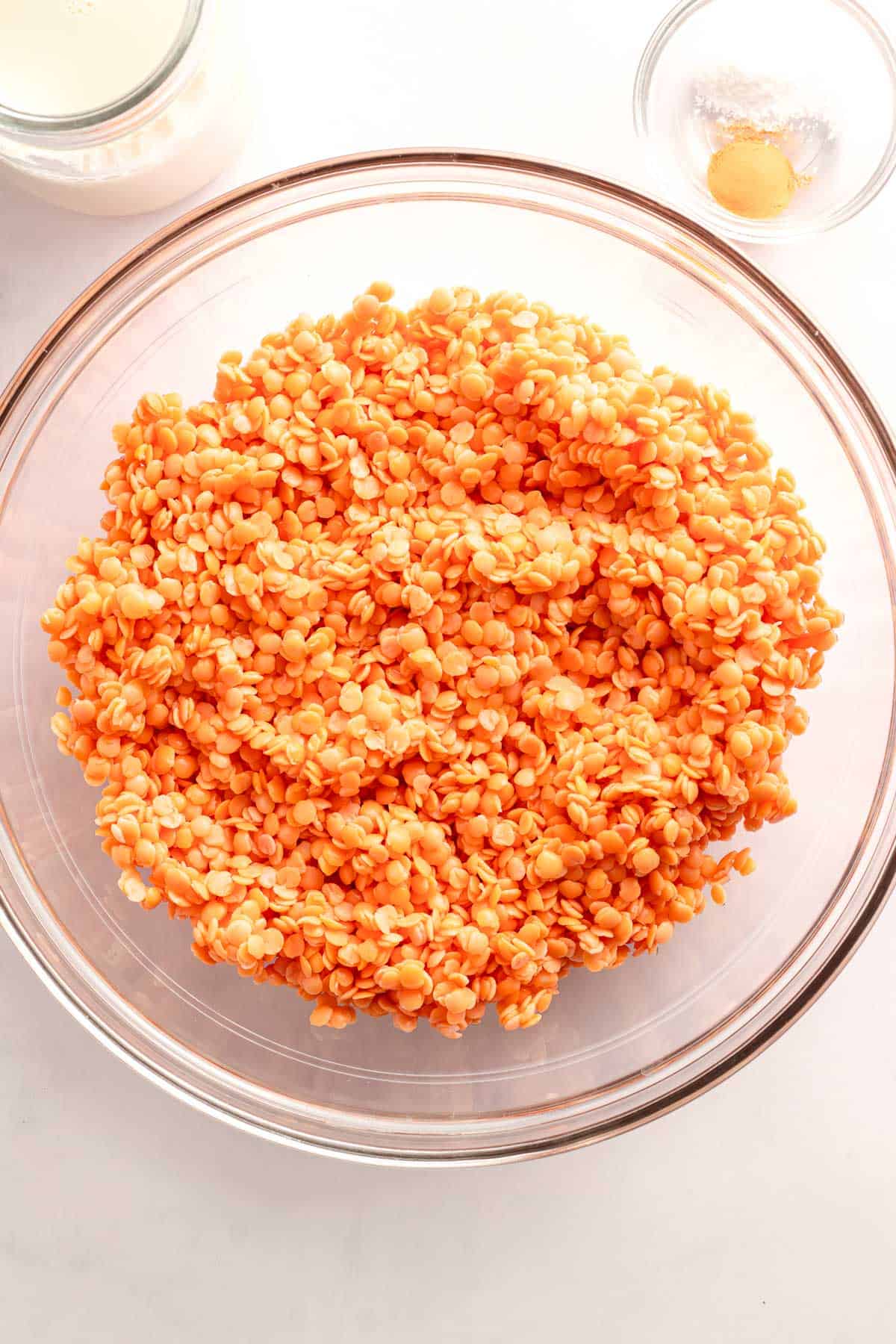 Soaked red lentils in a glass mixing bowl before blending