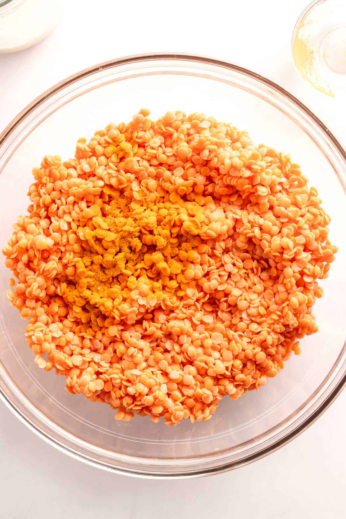 Soaked red lentils with turmeric in a glass bowl